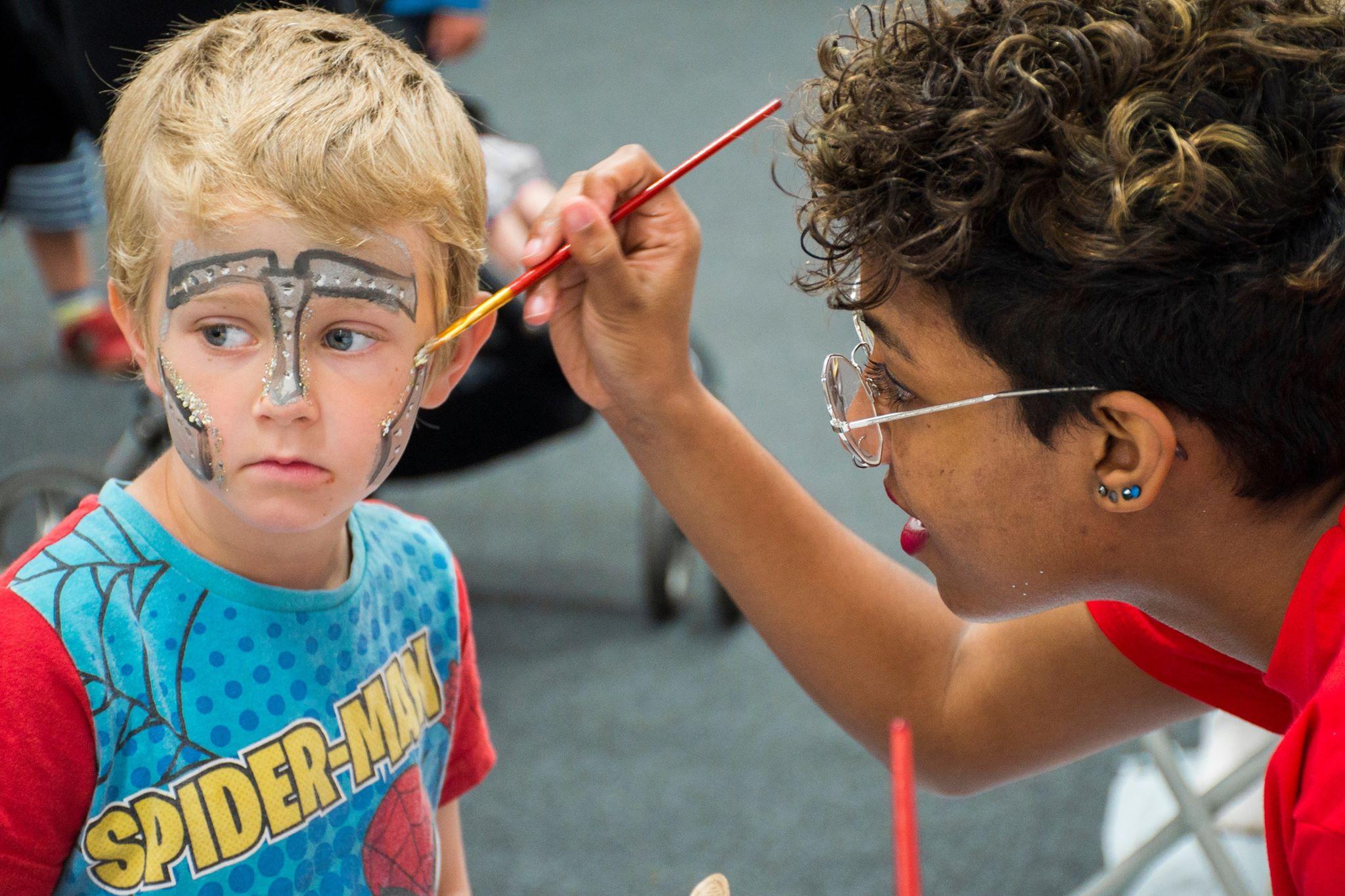 Rhyana working as a face painter with additional biodegradable glitters at The Garden Festival, Penryn