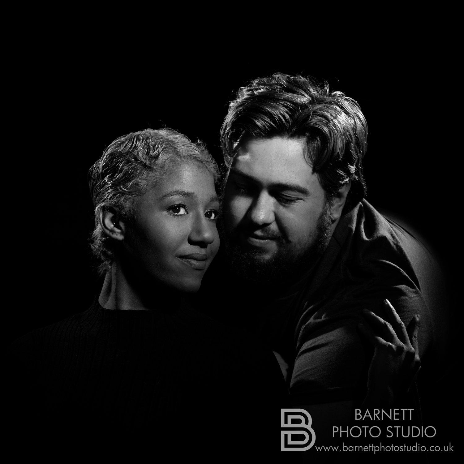 Black and white mid shot of Rhyana and partner Matt in an embrace, with Rhyana looking towards the camera.