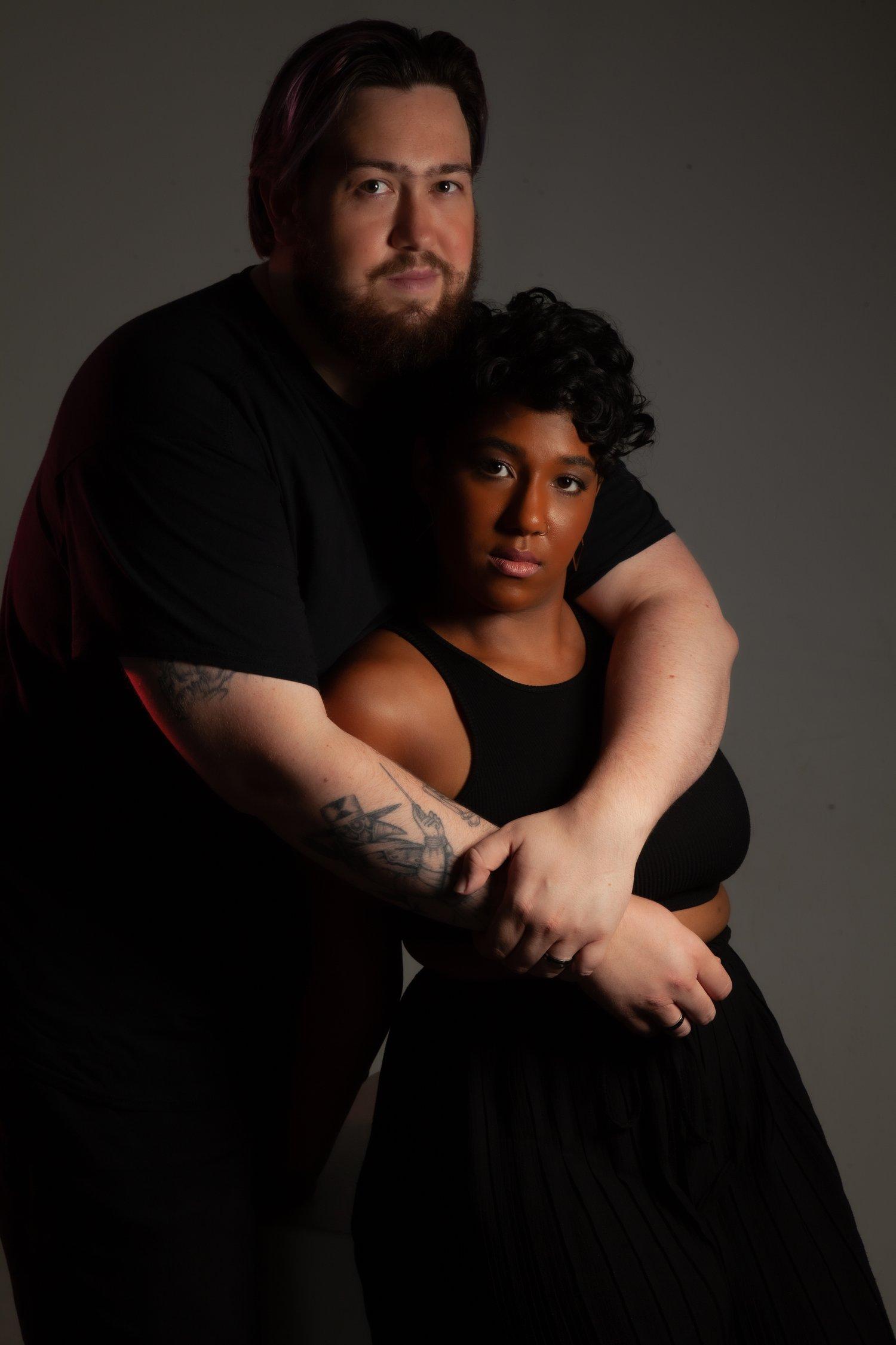 Rhyana sat in a black sleeveless top and matching skirt, being embraced from behind by Matt.