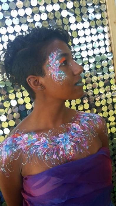 Rhyana with floral rainbow chest and face art.