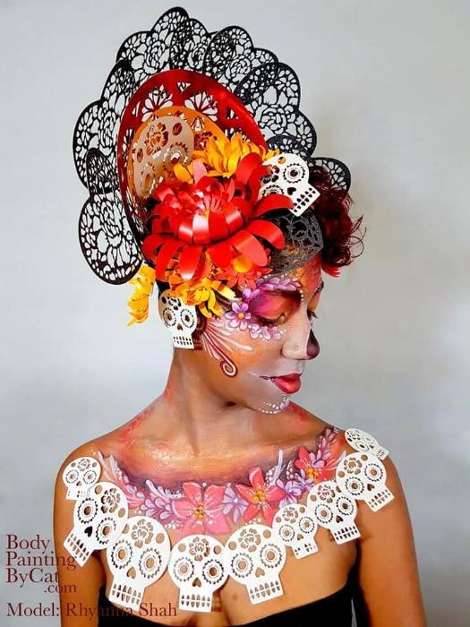 Rhyana dressed in black, white and red skull and flower motif against a white background.