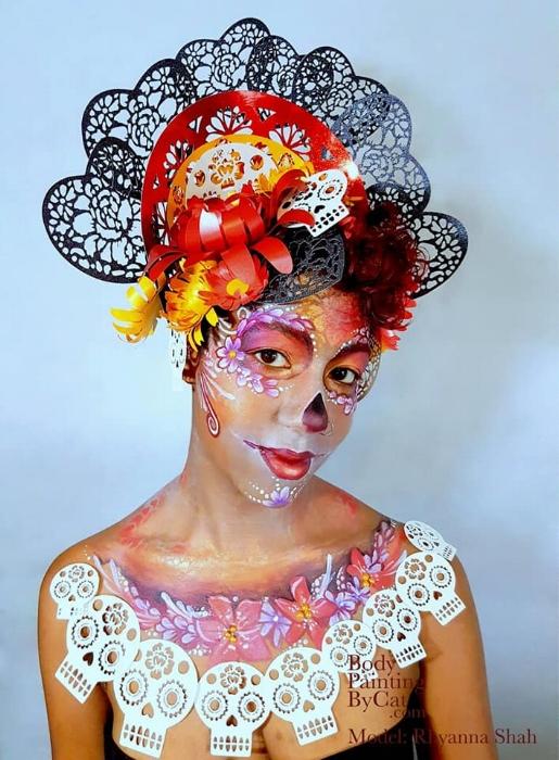 Rhyana looking towards the camera, dressed in a red, black and white skull motif outfit.