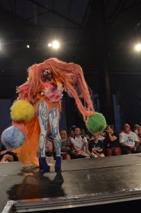 Rhyana on a modelling catwalk in a colourful fox costume.