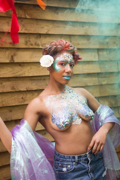 Rhyana posing topless in blue and silver body paint.