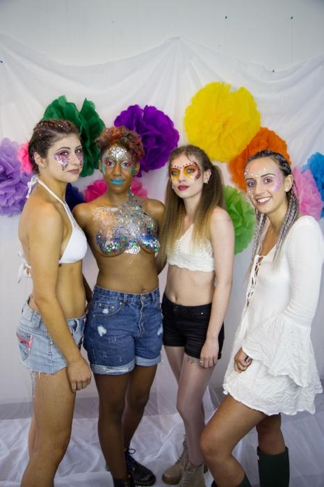 Rhyana with their arms around three fellow models, all smiling toward the camera.