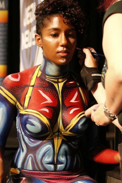Close up of Rhyana undergoing body painting to look like Ms. Marvel.
