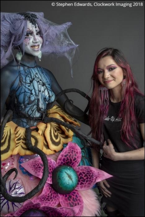 Rhyana smiling in a scary forest-themed outfit with designer Tawna Lee.