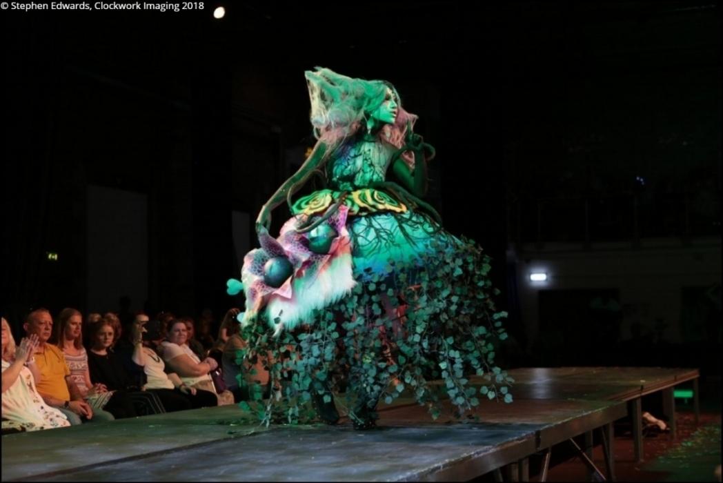 Rhyana in a forest-themed outfit on a modelling catwalk.