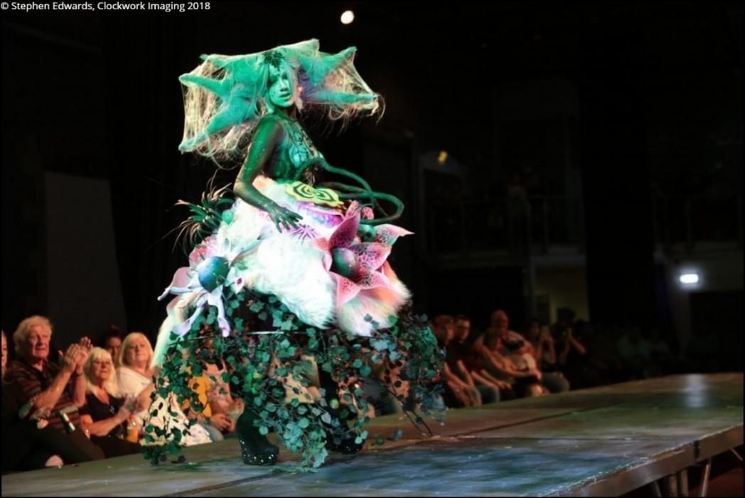 Mid shot of Rhyana in a forest-themed outfit on a modelling catwalk.