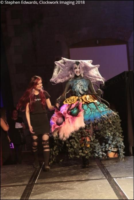 Rhyana in a forest-themed outfit, holding hands with designer Tawna Lee.