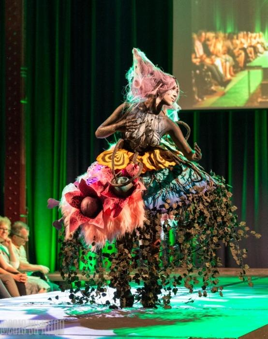 Rhyana on a modelling catwalk in a forest-themed outfit.