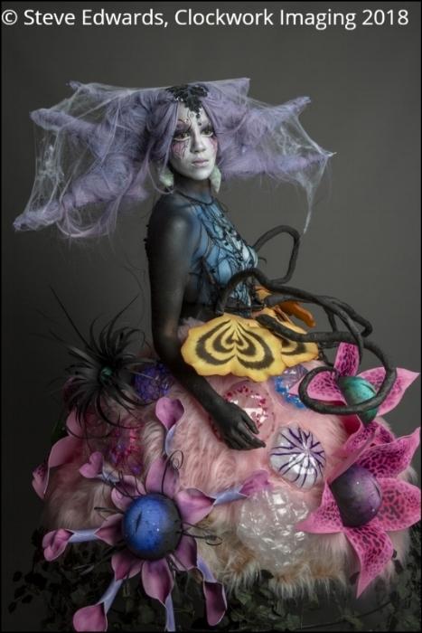 Rhyana in a spooky forest-themed outfit on a grey background.